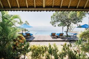 a view of a beach with chairs and umbrellas at The Angkal Resort in Nusa Penida