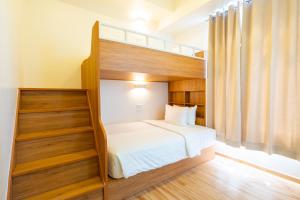 a bedroom with a bunk bed with white sheets at MySpace Hotel Comembo Taguig in Manila