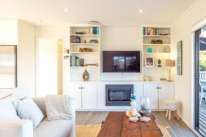 a living room with a couch and a tv at Skomer House in Oneroa