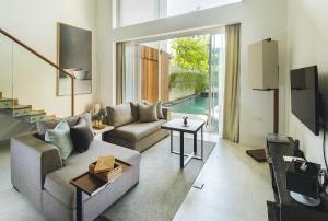 a living room with a couch and a table at Hu'u Villas in Seminyak