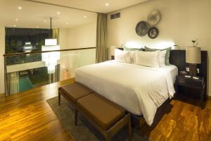 ein Schlafzimmer mit einem großen weißen Bett und einem Fenster in der Unterkunft hu'u Villas in Seminyak + 34 Fotos