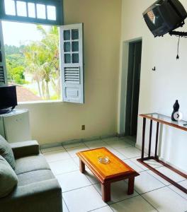 uma sala de estar com um sofá e uma mesa de centro em HOTEL SACRA FAMILIA -15 Km da Terra dos Dinos em Sacra Família do Tinguá