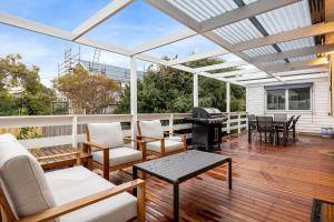 a screened in porch with a grill and furniture at Bay Cottage in Sorrento