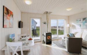 オルペニッツにあるStunning Home In Ostseeresort Olpenitz With Saunaのリビングルーム(暖炉、テーブル、椅子付)