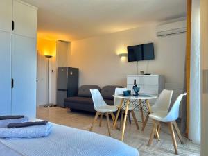 - une chambre avec une table, des chaises et un canapé dans l'établissement Cannes Marina vue mer, à Mandelieu-la-Napoule
