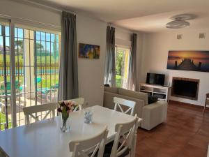 a living room with a table and a couch at Chalet con piscina en Novo Sancti Petri in Chiclana de la Frontera