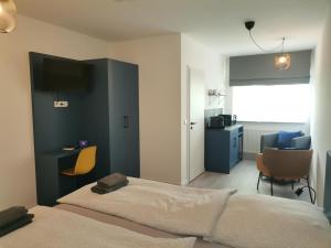 Schlafzimmer mit einem Bett, einem Schreibtisch und Stühlen in der Unterkunft Hotel A24 bei Hamburg in Glinde
