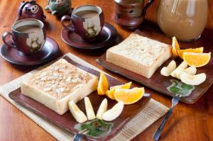 una mesa con dos rebanadas de pan y tazas de café en Family Pottery, en Hengchun