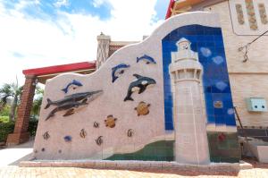 a mural on the side of a building with a lighthouse at Family Pottery in Hengchun South Gate
