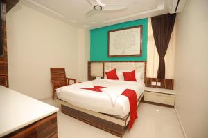 a bedroom with a large white bed with red pillows at Sree Bharat Residency in Alāndurai