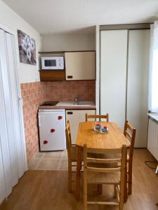 a kitchen with a table and chairs in a room at Studio Font-Romeu avec place de parking in Font-Romeu-Odeillo-Via