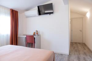 ein Schlafzimmer mit einem Bett und einem Tisch sowie einem TV an der Wand in der Unterkunft Hotel San Francisco in Lido di Savio