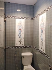 une salle de bain avec toilettes et deux tableaux au mur dans l'établissement TAGAYTAY BGC, à Tagaytay 10 autres photos