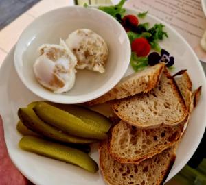 a plate with a sandwich and a bowl of ice cream and pickles at Hotel Alpex View in Zabrze