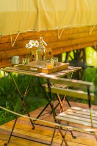 a table and a chair with flowers on it at Dragonfly Gardens - The Wagons in Braşov
