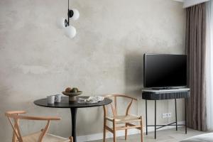 a living room with a table and chairs and a tv at Flatbook - City Center Apartments Dwie Motławy in Gdańsk