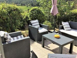 patio con sedie, tavolo e ombrellone di Charming holiday home with private pool a Montbrun-des-Corbières