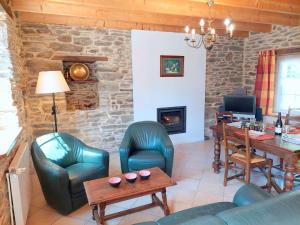 sala de estar con sillas, mesa y chimenea en Cottage, Plouenan, en Plouénan