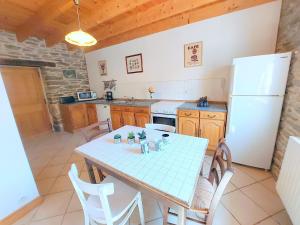 a kitchen with a table and a white refrigerator at Cottage, Plouenan in Plouénan