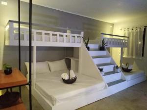 a bedroom with a bunk bed with a staircase at PAYAG SUITES in General Luna