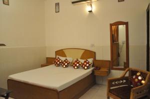 a bedroom with a bed with pillows and a mirror at Hotel Surya Palace in Chandīgarh
