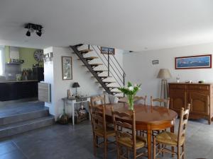 a dining room with a table and a spiral staircase at Charming, fully renovated stone house in Bricqueville-sur-Mer
