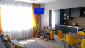 a living room with a table and yellow chairs at Panorama apartment in Varna City +7 photos