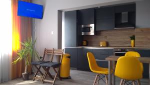 a kitchen with yellow chairs and a table in a room at Panorama apartment in Varna City