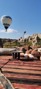 a hot air balloon flying over a picnic table at Salkım Cave House in Göreme