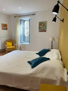 een slaapkamer met een groot wit bed met 2 kussens bij La Secrète in Vogüé