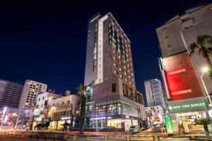 a tall building in a city at night at Hotel Haema in Jeju