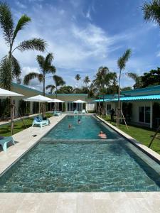 einen Pool in einem Resort mit Leuten darin in der Unterkunft Le Petit Saint Tropez in Khanom