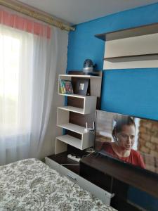 ein Schlafzimmer mit einem Schreibtisch mit einem Bild einer Frau in der Unterkunft Viršu street apartaments 5 in Liepāja