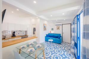 cocina y sala de estar con sofá azul en Villetta Actea, en Positano