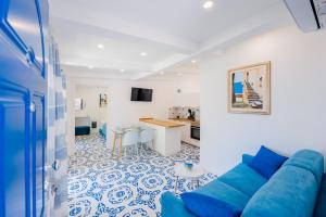 sala de estar con sofá azul y cocina en Villetta Actea, en Positano