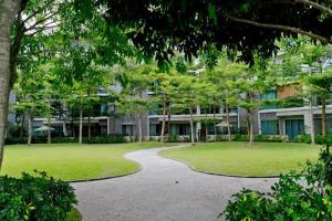 uma passarela num parque com árvores e um edifício em Bulan Guesthouse Imago em Kota Kinabalu