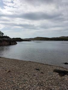 a large body of water with a rocky shore at Lavender hut in Brackloch