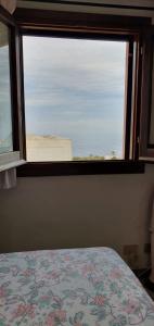 a bedroom with a window with a bed and a view at La casetta di Kamma in Kamma