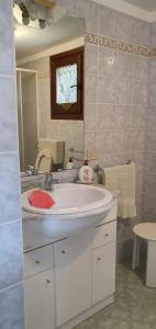 a bathroom with a white sink and a mirror at La casetta di Kamma in Kamma