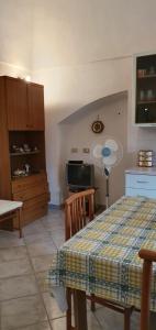 a living room with a table and a kitchen at La casetta di Kamma in Kamma