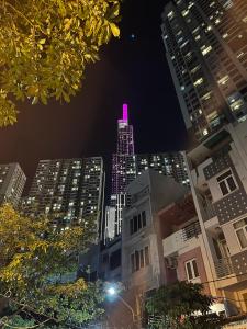 a tall building with a pink lit up top at night at Feli Home 1 - Close to Landmark 81 in Ho Chi Minh City