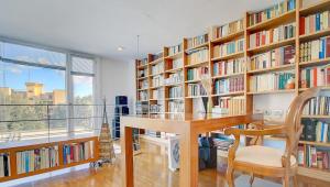 biblioteka ze stołem, krzesłami i półkami na książki w obiekcie Villa Bonanova Style w Palma de Mallorca