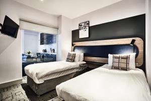 a bedroom with two beds and a living room at Quest Liverpool City Centre in Liverpool