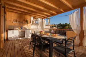 a dining room with a table and chairs on a deck at Mara's Coast - Ella in Drage