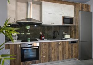 eine Küche mit Holzschränken und einem Edelstahlkühlschrank in der Unterkunft Rena's luxury apartment with free private parking in Chania