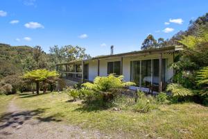a house on a field with trees and plants at Cooinda in Apollo Bay