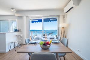 a dining room with a table with a bowl of fruit on it at SERRENDY Renovated apartment with sea view in Cannes
