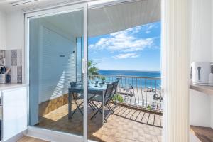 a balcony with a table and a view of the ocean at SERRENDY Renovated apartment with sea view in Cannes