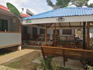 a pavilion with a bench in front of a house at Bundal Riverside Room #3 in San Vicente