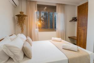 a bedroom with a white bed and a window at Aesthisis Sensational Accommodation in Kolimbia